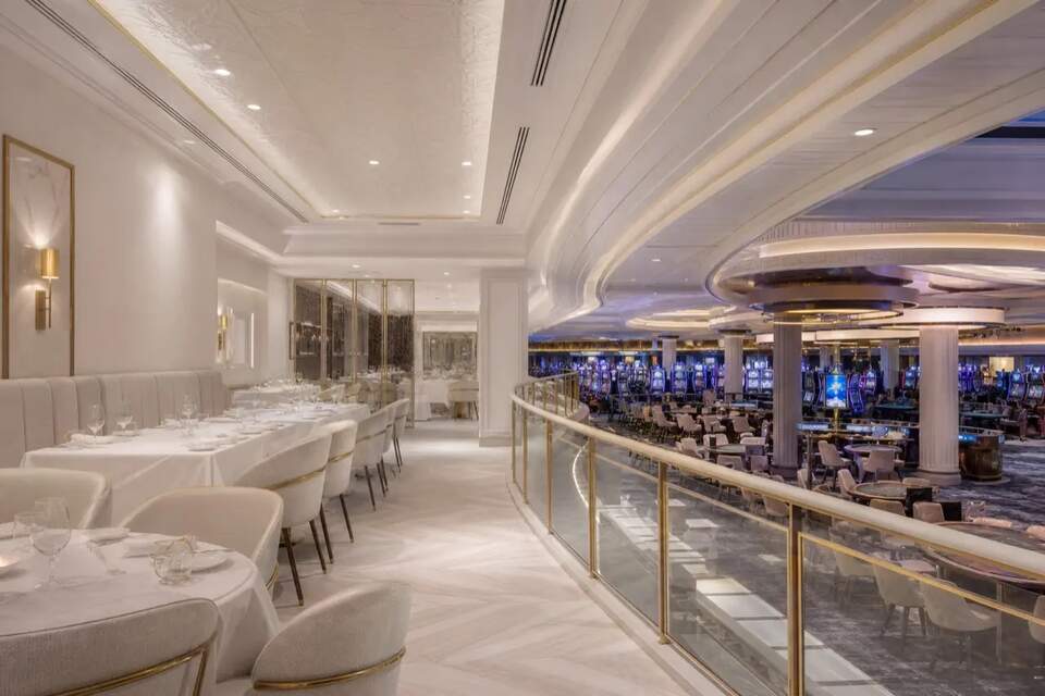 Restaurant lounge with white tables beside the gaming floor